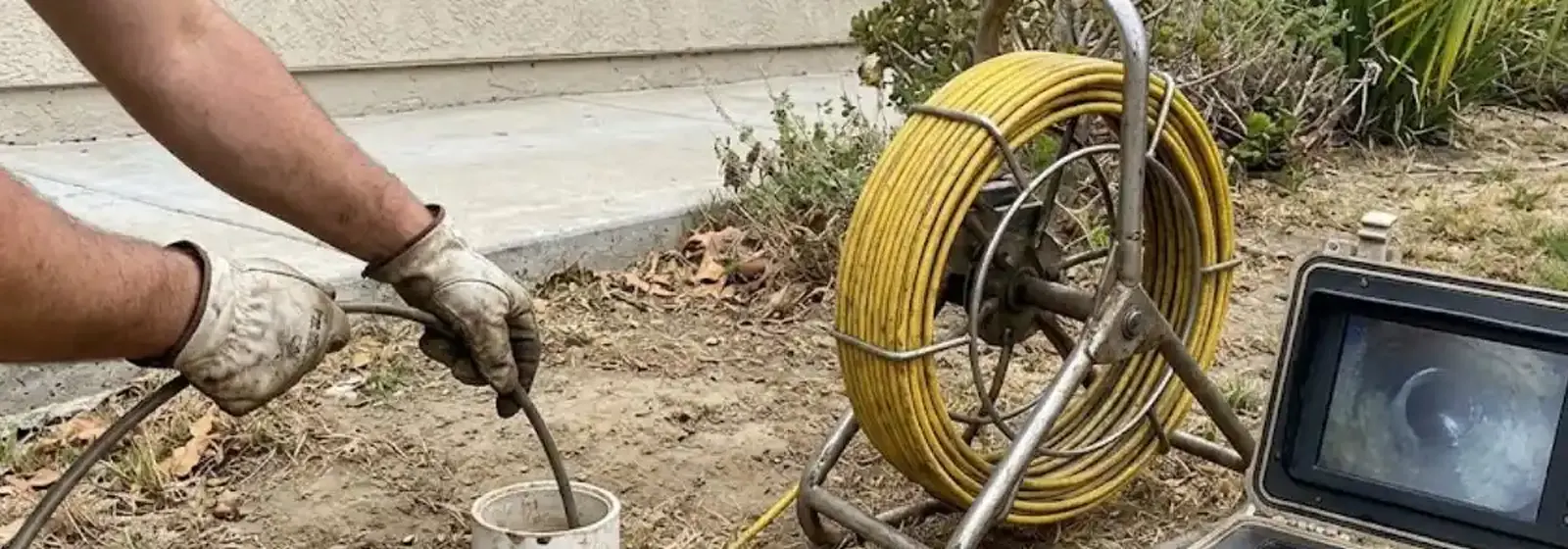 Sewer camera reel and monitor set up at a yard cleanout